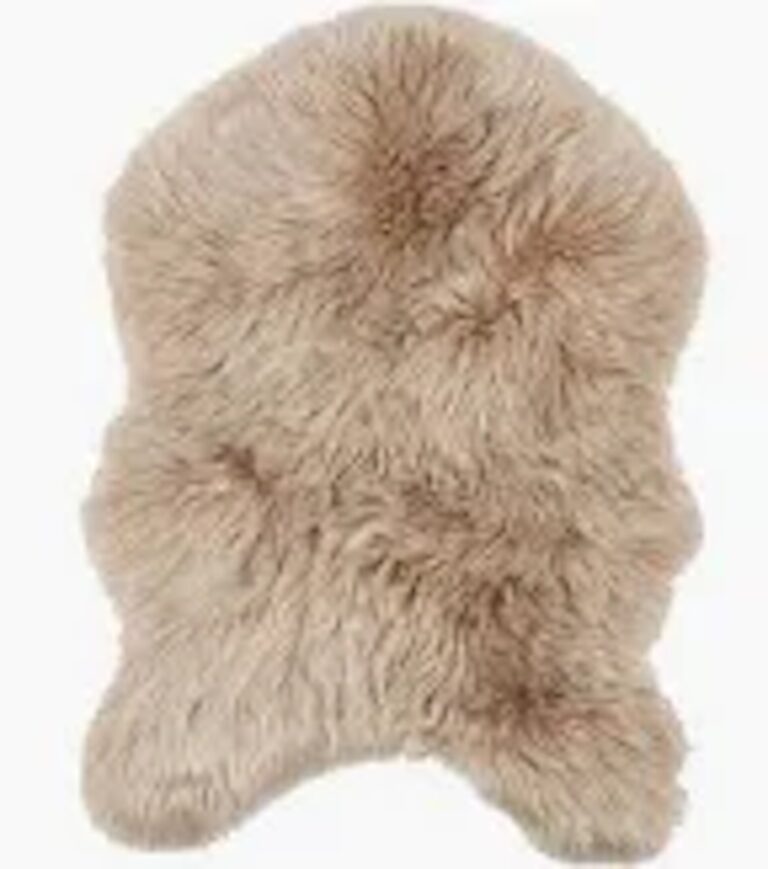 „Kunstfelle“ ist ein beiger, flauschiger Teppich mit der weichen Textur und dem gemütlichen Aussehen eines abstrakten Tierfells.