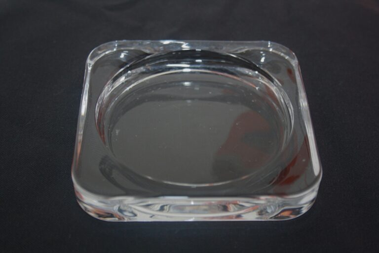 Der Glasunterlage Liora ist ein klarer, quadratischer Aschenbecher aus Glas mit abgerundeten Ecken und einer kreisförmigen Vertiefung in der Mitte. Er eignet sich zur Aufbewahrung von Asche oder kleinen Gegenständen. Er passt elegant zu jeder dunklen Oberfläche.